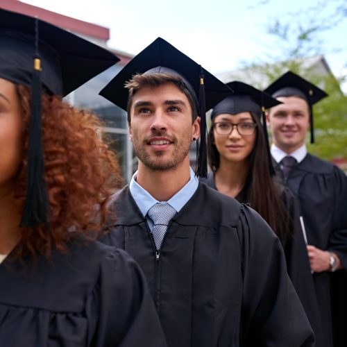 Education, university and students in row for graduation dreaming and thinking of future. Smile, waiting and group of young people in line for college degree, diploma or certificate by campus